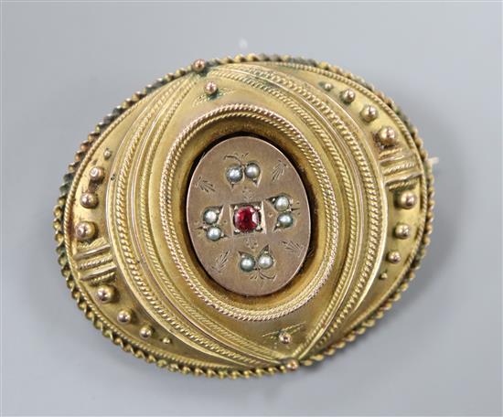 A Victorian yellow metal seed pearl and ruby set oval brooch, with glazed back, 42mm.